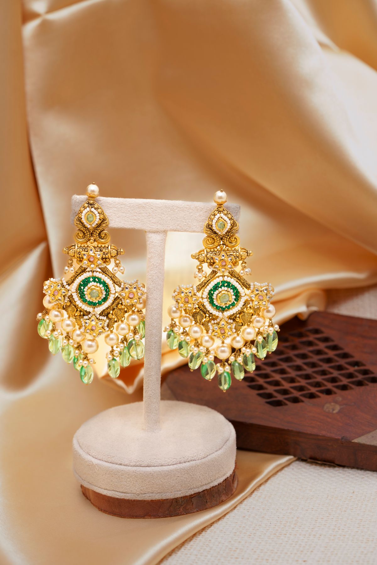 Antique-finish chandbali earrings with pearl drops on champagne satin